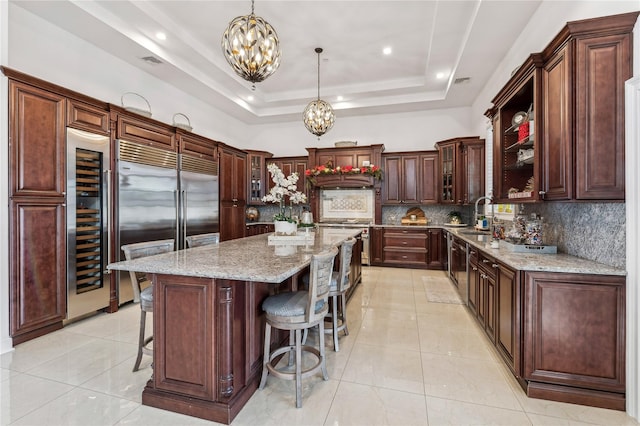 2854 Whaleneck Dr, Merrick, NY 11566 - kitchen with a chandelier, wine cooler, a raised ceiling, decorative backsplash, and open shelves