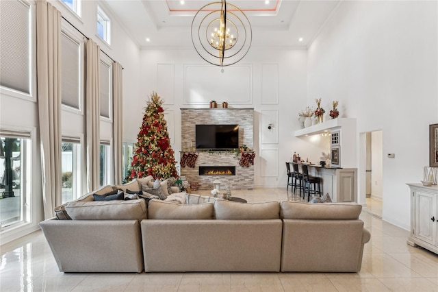 2854 Whaleneck Dr, Merrick, NY 11566 - living area with a high ceiling, a chandelier, a stone fireplace, ornamental molding, and a tray ceiling