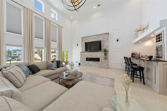2854 Whaleneck Dr, Merrick, NY 11566 - living area with a towering ceiling, a fireplace, light tile patterned flooring, a chandelier, and recessed lighting