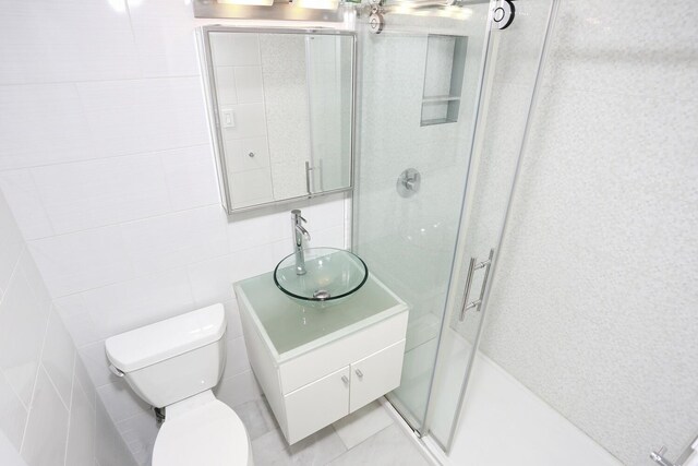 311 71st St E Unit 10A, New York Manhattan, NY 10021 - full bathroom with tile walls, vanity, and a shower stall