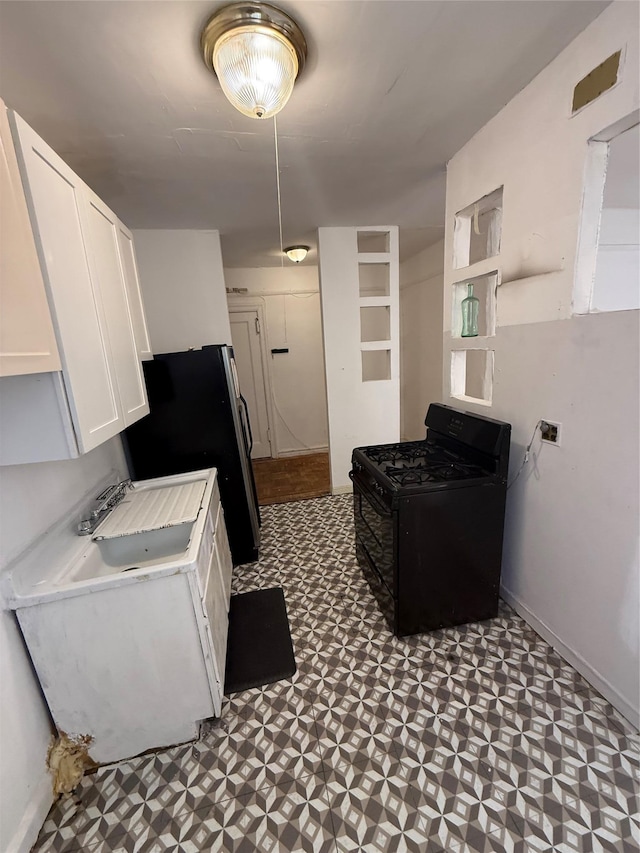 1177 Anderson Ave Unit 2B, Bronx, NY 10452 - kitchen with gas stove, tile patterned floors, white cabinets, light countertops, and freestanding refrigerator