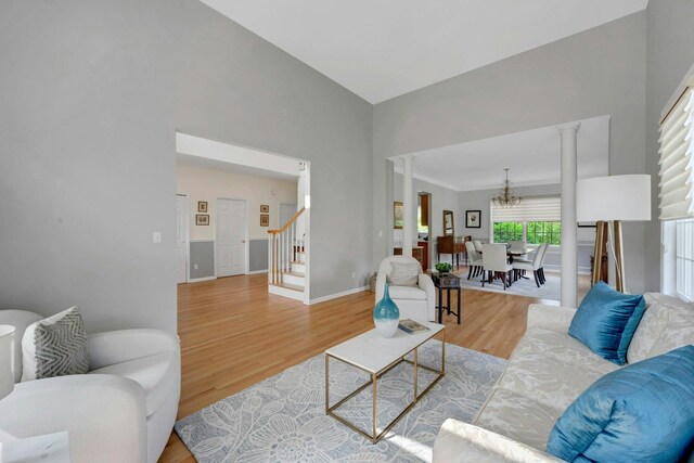 3 Vista Dr, Baldwin Place, NY 10505 - living area with decorative columns, a chandelier, stairway, wood finished floors, and a towering ceiling