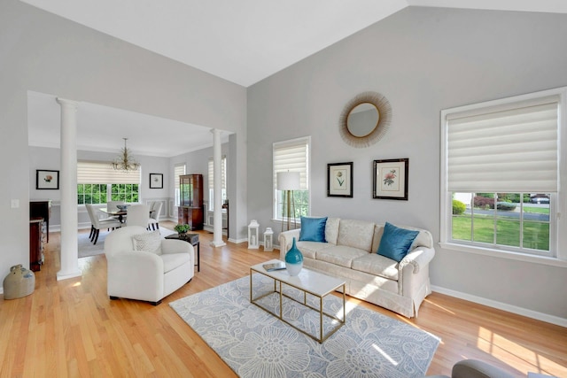 3 Vista Dr, Baldwin Place, NY 10505 - living area with decorative columns, a chandelier, light wood-style floors, and vaulted ceiling