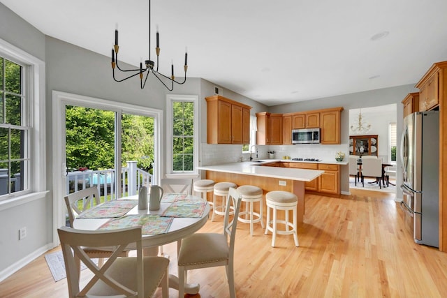 3 Vista Dr, Baldwin Place, NY 10505 - kitchen with appliances with stainless steel finishes, light countertops, a peninsula, decorative backsplash, and light wood-type flooring