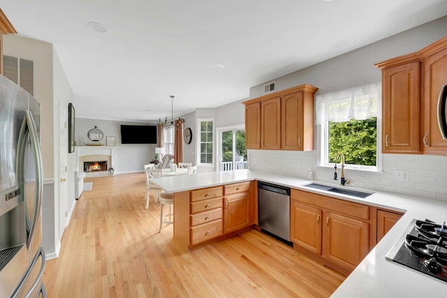 3 Vista Dr, Baldwin Place, NY 10505 - kitchen featuring appliances with stainless steel finishes, a peninsula, light wood-style flooring, tasteful backsplash, and light countertops