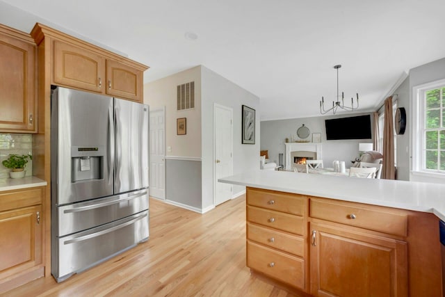 3 Vista Dr, Baldwin Place, NY 10505 - kitchen featuring stainless steel refrigerator with ice dispenser, light wood-type flooring, open floor plan, a warm lit fireplace, and light countertops