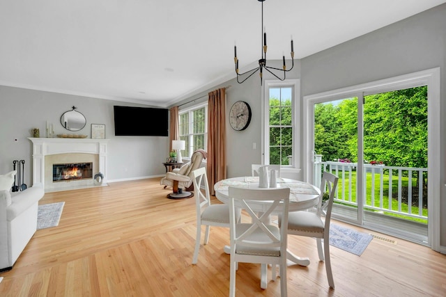 3 Vista Dr, Baldwin Place, NY 10505 - dining area with a chandelier, a fireplace with flush hearth, light wood finished floors, and crown molding