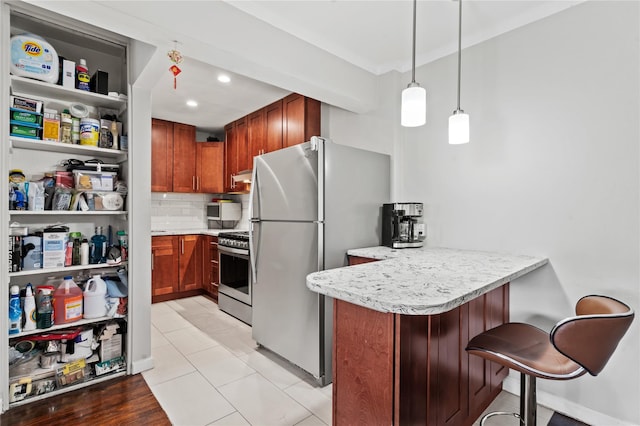 68-20 Selfridge St Unit 6J, Forest Hills, NY 11375 - kitchen with stainless steel appliances, a peninsula, light countertops, tasteful backsplash, and decorative light fixtures