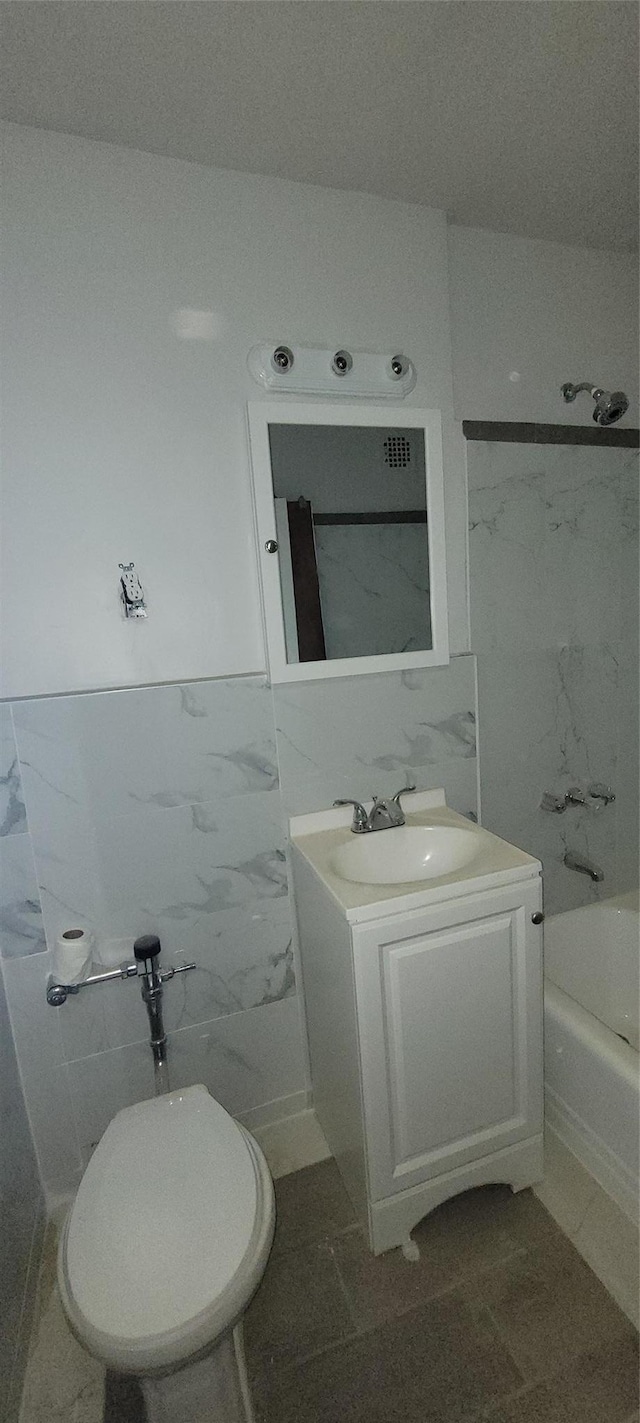 92-29 Lamont Ave Unit 2C, Elmhurst, NY 11373 - bathroom featuring vanity, tile walls, marble finish flooring, washtub / shower combination, and wainscoting