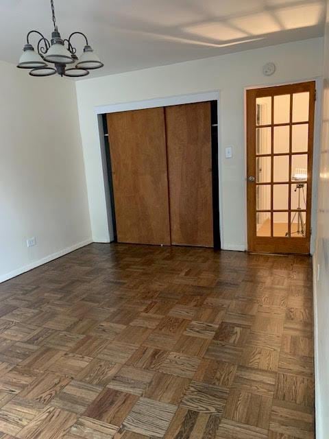 92-29 Lamont Ave Unit 2C, Elmhurst, NY 11373 - unfurnished bedroom featuring a chandelier and a closet