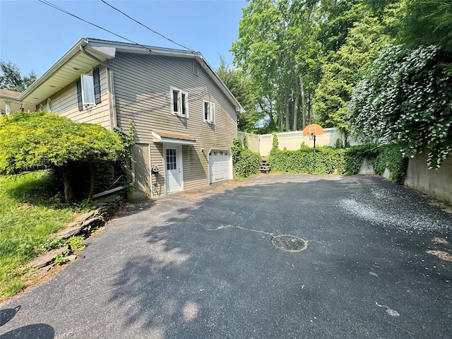 70 Nichols Rd, Nesconset, NY 11767 - view of side of home featuring driveway and an attached garage
