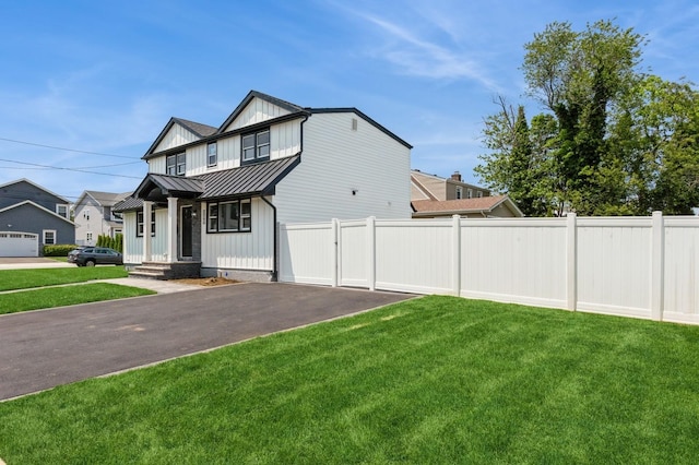 1541 Midian St, North Merrick, NY 11566 - view of front of house featuring a standing seam roof, board and batten siding, driveway, and metal roof