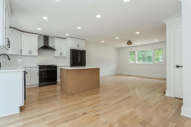 1541 Midian St, North Merrick, NY 11566 - kitchen with black appliances, wall chimney exhaust hood, a kitchen island, recessed lighting, and light wood finished floors