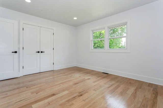 1541 Midian St, North Merrick, NY 11566 - unfurnished bedroom with baseboards, light wood-style floors, recessed lighting, and a closet