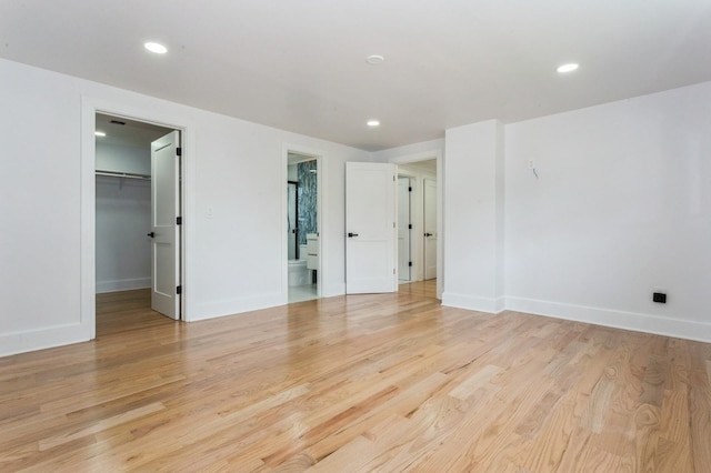 1541 Midian St, North Merrick, NY 11566 - unfurnished bedroom featuring a walk in closet, light wood-style floors, baseboards, and recessed lighting