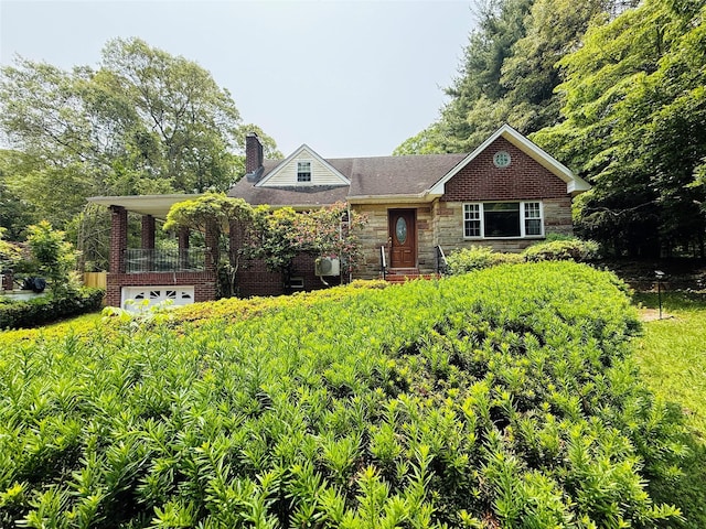 56 Elwood Rd, Northport, NY 11768 - view of front of home with a chimney, stone siding, and a garage