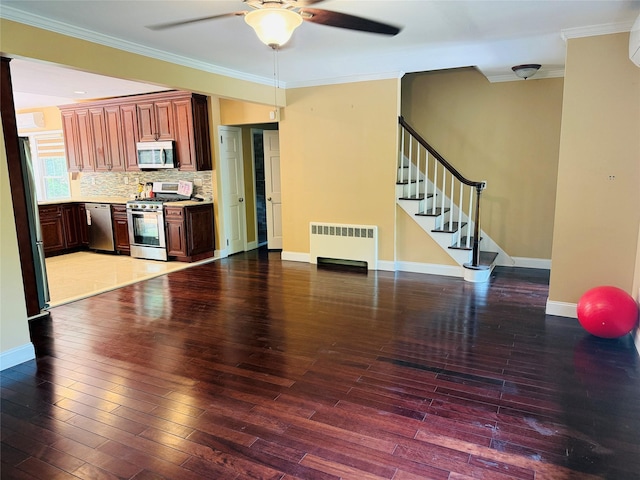 56 Elwood Rd, Northport, NY 11768 - kitchen featuring appliances with stainless steel finishes, radiator heating unit, a ceiling fan, ornamental molding, and light countertops
