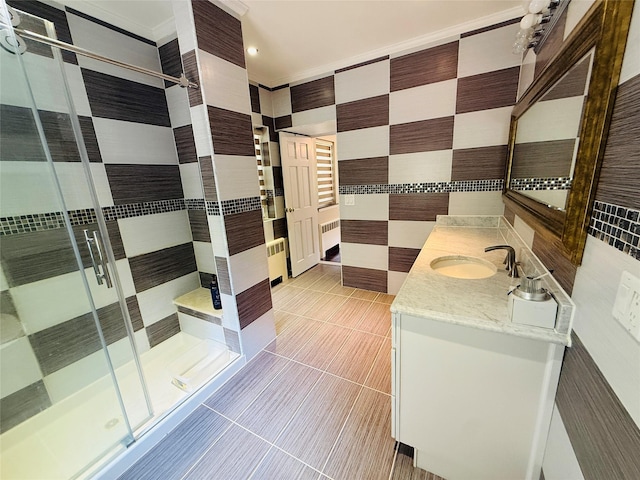 56 Elwood Rd, Northport, NY 11768 - full bathroom with a stall shower, vanity, radiator, tile walls, and tile patterned floors