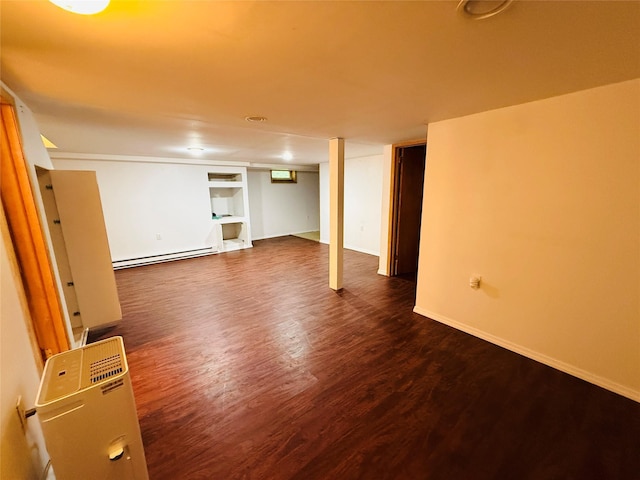 56 Elwood Rd, Northport, NY 11768 - finished below grade area with a baseboard radiator, dark wood-type flooring, built in features, and baseboards