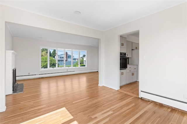 167 Secatogue Ln W, West Islip, NY 11795 - unfurnished living room with light wood finished floors, a baseboard radiator, baseboards, and a wood stove
