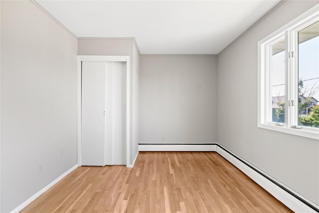 167 Secatogue Ln W, West Islip, NY 11795 - unfurnished bedroom featuring a baseboard radiator, light wood finished floors, baseboard heating, baseboards, and a closet