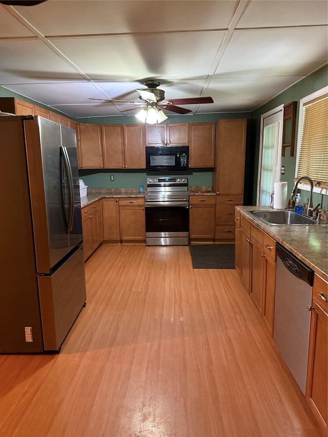 1546 Denning Rd, Claryville, NY 12725 - kitchen featuring appliances with stainless steel finishes, a sink, brown cabinetry, light wood-style flooring, and ceiling fan