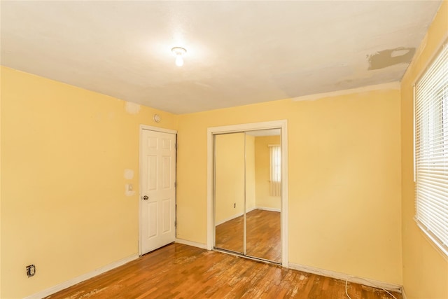 18 Hilliard Ave, Central Islip, NY 11722 - unfurnished bedroom featuring wood finished floors, a closet, and baseboards