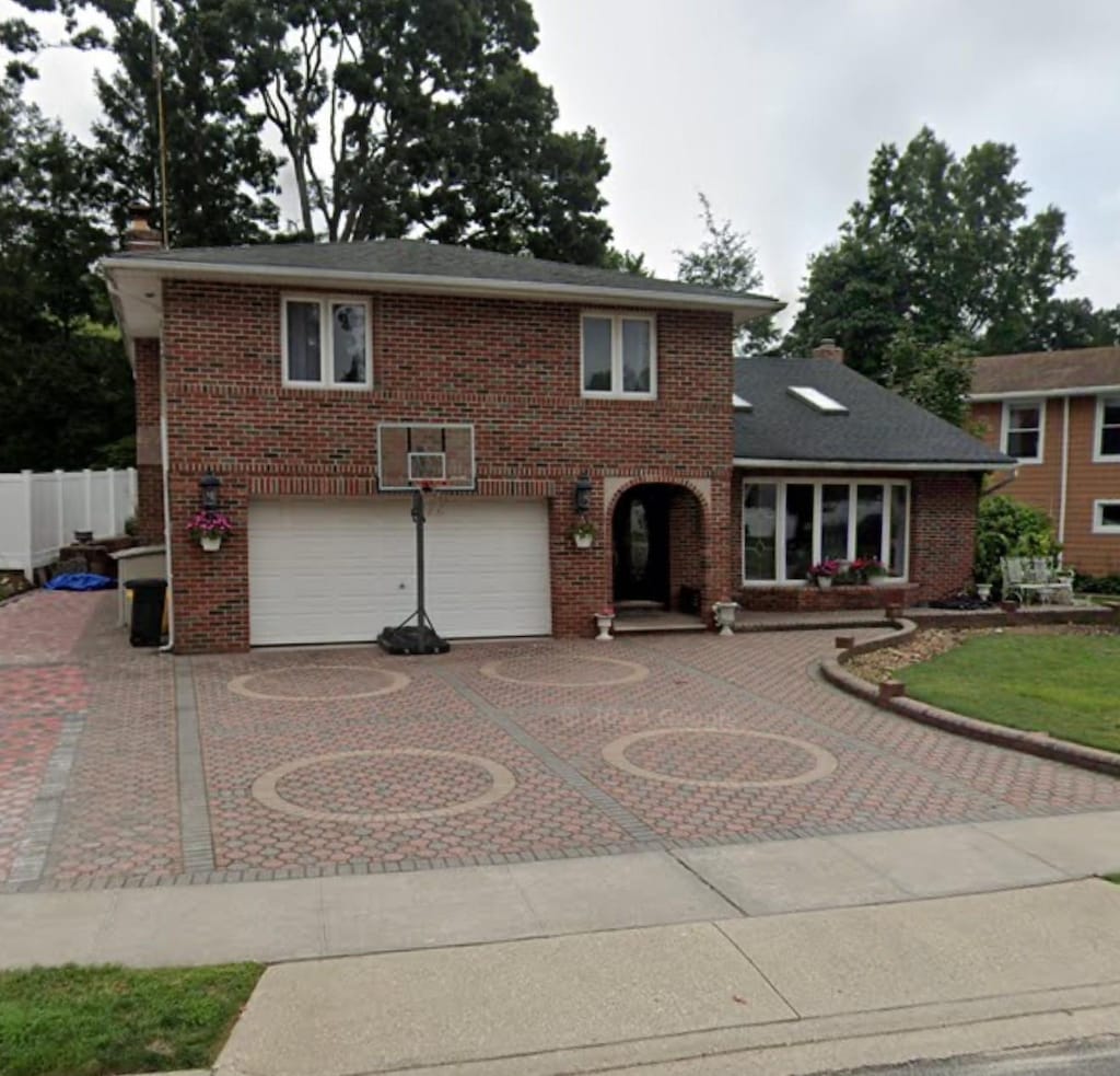 48 Robin Ln, Plainview, NY 11803 - traditional-style home featuring a garage, curved driveway, and brick siding