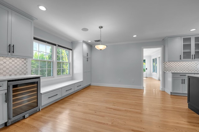 56 Washington Ave, Garden City, NY 11530 - kitchen with beverage cooler, gray cabinets, crown molding, plenty of natural light, and tasteful backsplash
