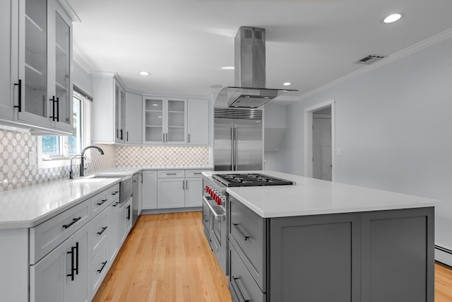56 Washington Ave, Garden City, NY 11530 - kitchen featuring premium appliances, island range hood, a sink, a center island, and ornamental molding