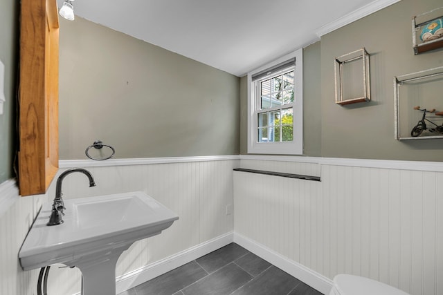 56 Washington Ave, Garden City, NY 11530 - bathroom with a wainscoted wall, toilet, a sink, and tile patterned floors