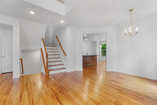 19 Woodrose Ct, Middletown, NY 10940 - unfurnished living room with light wood finished floors, a chandelier, recessed lighting, baseboards, and stairs
