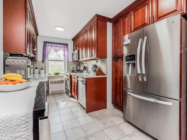 1234 Midland Ave Unit 5C, Bronxville, NY 10708 - kitchen featuring stainless steel appliances, radiator, decorative backsplash, and light tile patterned flooring