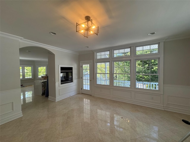 20 Frost Valley Rd, Mount Sinai, NY 11766 - unfurnished living room featuring a decorative wall, arched walkways, crown molding, a wainscoted wall, and recessed lighting