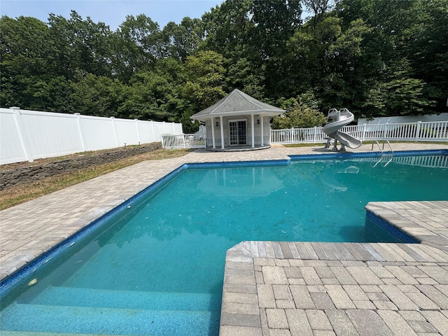 20 Frost Valley Rd, Mount Sinai, NY 11766 - view of swimming pool featuring a water slide, a fenced backyard, a patio area, and an outdoor structure