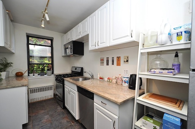 142 Garth Rd Unit 1A, Scarsdale, NY 10583 - kitchen with appliances with stainless steel finishes, radiator, a sink, white cabinetry, and light stone counters