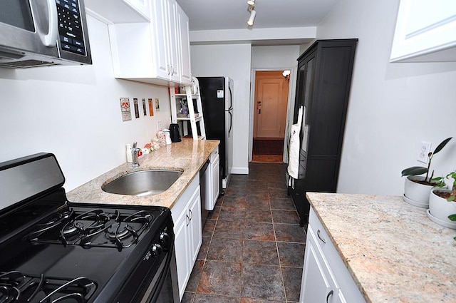 142 Garth Rd Unit 1A, Scarsdale, NY 10583 - kitchen with gas range, stainless steel microwave, a sink, freestanding refrigerator, and white cabinets