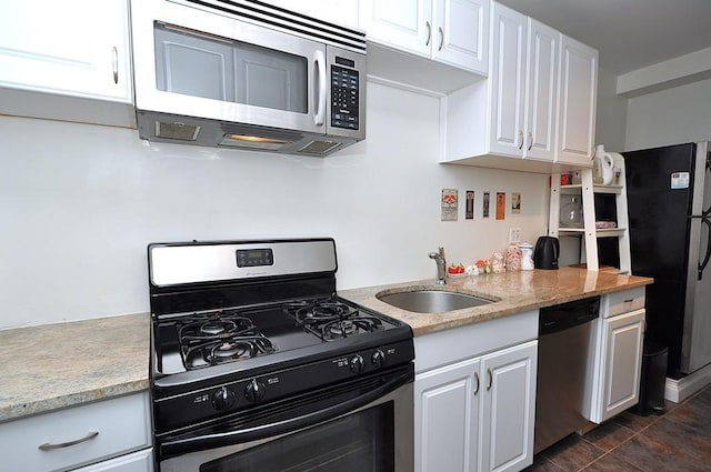 142 Garth Rd Unit 1A, Scarsdale, NY 10583 - kitchen featuring stainless steel appliances, a sink, white cabinets, and light stone counters
