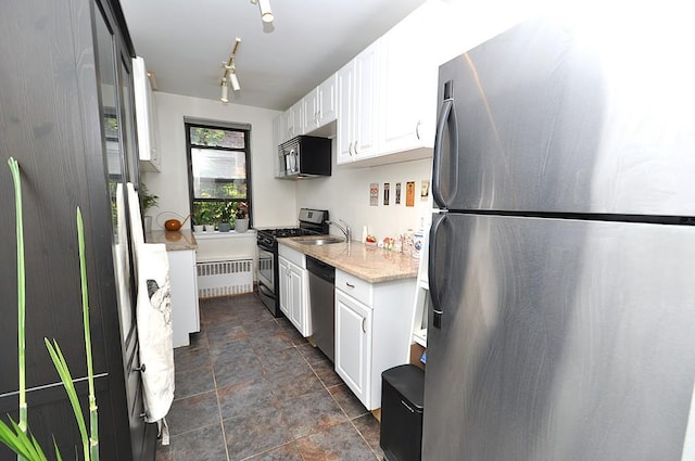 142 Garth Rd Unit 1A, Scarsdale, NY 10583 - kitchen featuring stainless steel appliances, stone finish floors, radiator, white cabinets, and light stone counters