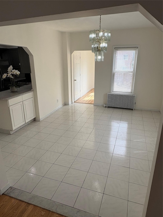840 Hollywood Ave, Bronx, NY 10465 - unfurnished dining area featuring radiator heating unit, a chandelier, light tile patterned floors, baseboards, and arched walkways