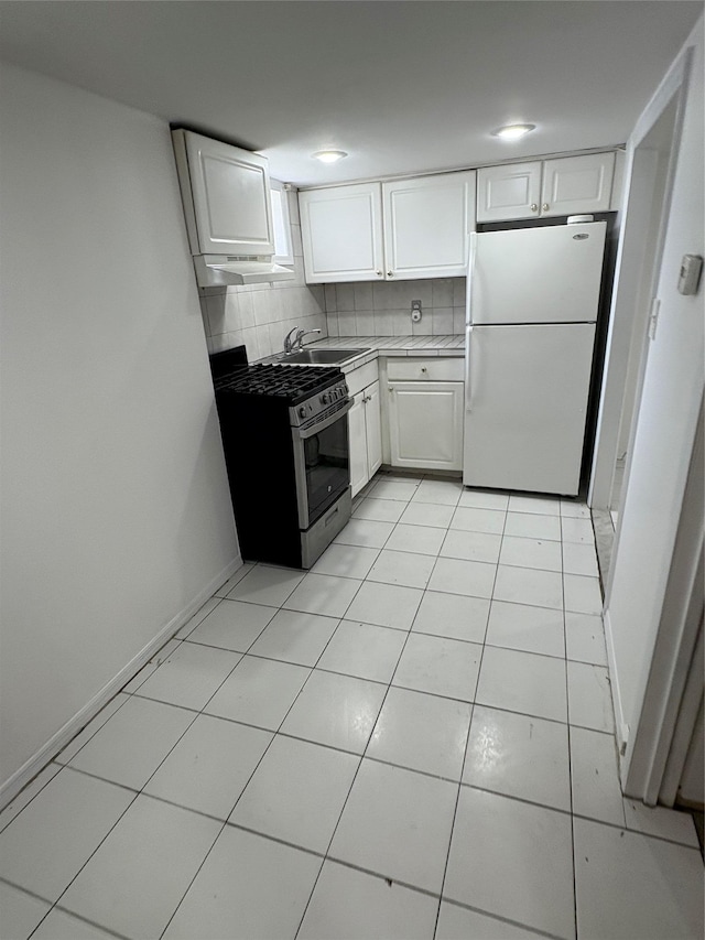 840 Hollywood Ave, Bronx, NY 10465 - kitchen featuring freestanding refrigerator, stainless steel range with gas stovetop, white cabinets, and backsplash