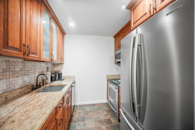 67 Richmond Blvd Unit 2A, Ronkonkoma, NY 11779 - kitchen with stainless steel appliances, a sink, tasteful backsplash, light stone counters, and brown cabinetry