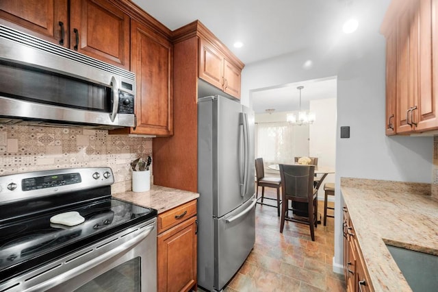 67 Richmond Blvd Unit 2A, Ronkonkoma, NY 11779 - kitchen featuring appliances with stainless steel finishes, tasteful backsplash, a chandelier, light stone countertops, and recessed lighting