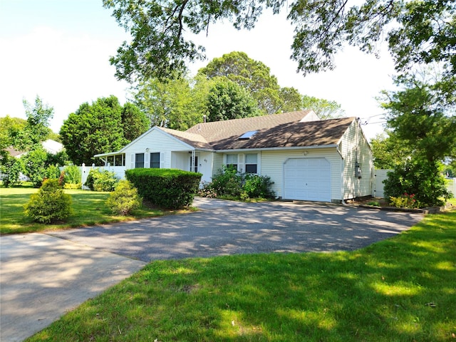 single story home with driveway, an attached garage, and a front yard