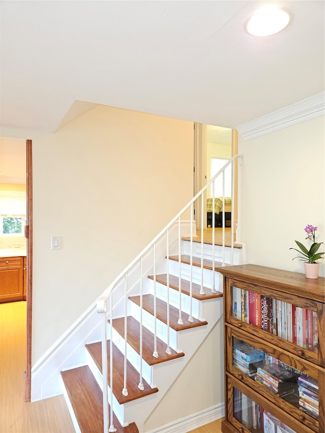 stairs featuring baseboards and crown molding