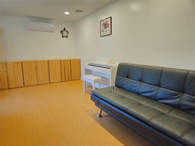 living area with a wall mounted AC, light wood finished floors, and recessed lighting