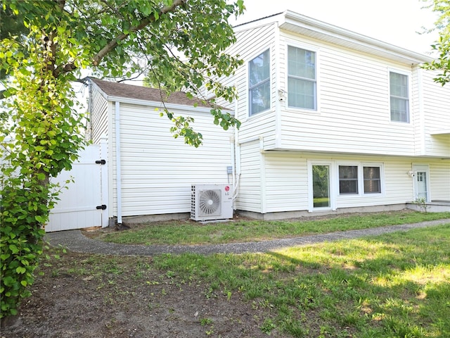 view of side of property featuring ac unit and a yard