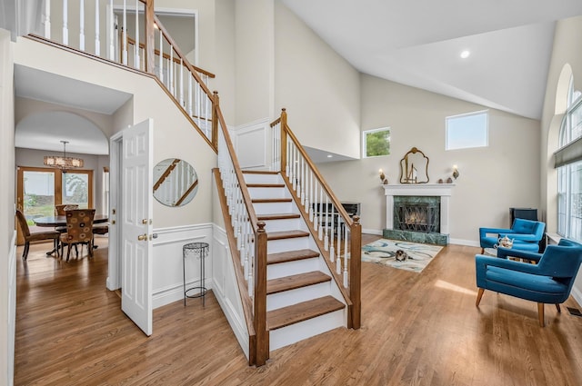 8 Tecumseh Ct, Commack, NY 11725 - stairway featuring high vaulted ceiling, wood finished floors, a premium fireplace, a chandelier, and baseboards