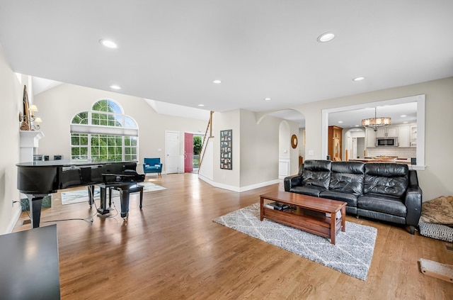 8 Tecumseh Ct, Commack, NY 11725 - living room with recessed lighting, wood finished floors, arched walkways, baseboards, and a chandelier