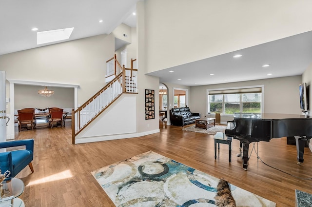 8 Tecumseh Ct, Commack, NY 11725 - living room featuring stairway, wood finished floors, a chandelier, a skylight, and a towering ceiling